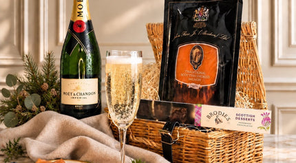 Champagne gift hamper with smoked salmon and boxed chocolates, styled with a champagne flute and strawberries.