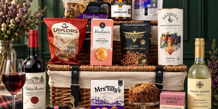 Scottish food and wine hamper with tea, biscuits, cake, fudge, preserves and savoury snacks.