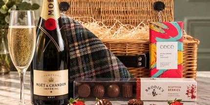 Moët champagne and chocolate hamper in an open wicker basket, with chocolate truffles and a champagne flute.