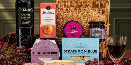 Port and cheese hamper with Scottish cheese truckles, blue cheese, oatcakes and chutney in a wicker basket.
