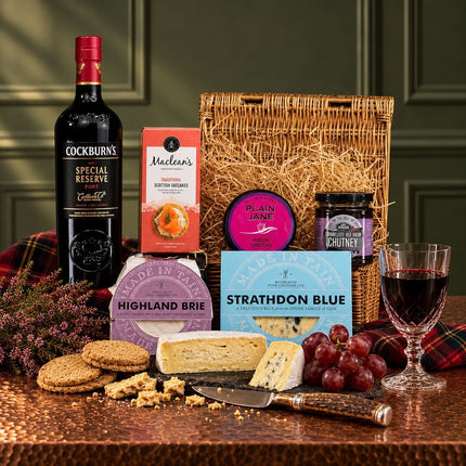 Port and cheese hamper with Scottish cheese truckles, blue cheese, oatcakes and chutney in a wicker basket.
