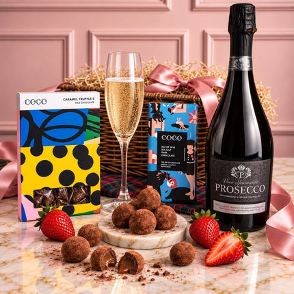 Prosecco and chocolate hamper with chocolate bars and caramel truffles, styled with a champagne flute and strawberries.