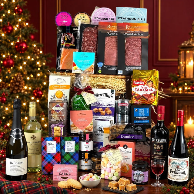 Scottish Festive Feast Hamper with cheese, smoked meats, biscuits, sweets, wine, prosecco and port beside a Christmas tree.