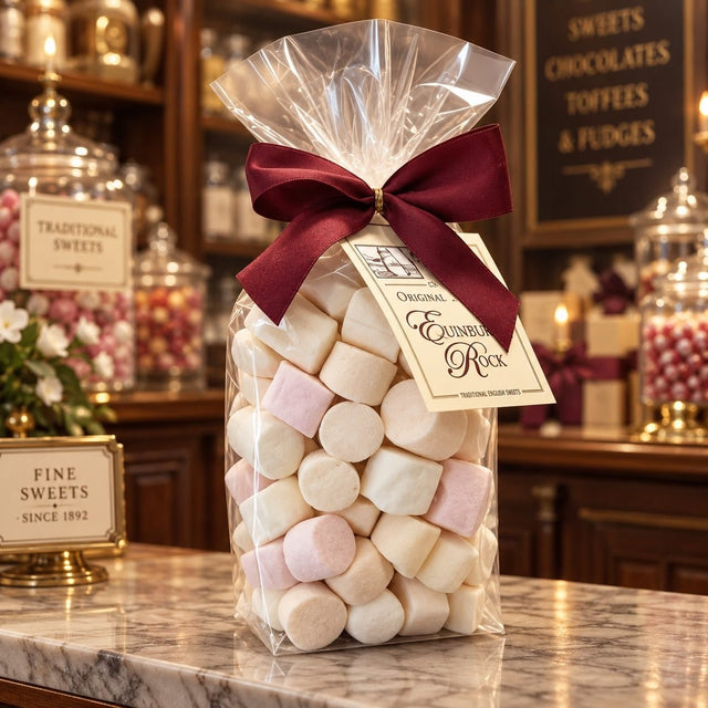 Ribbon-tied bag of Gordon & Durward Edinburgh Rock sweets on a counter in a traditional sweet shop.