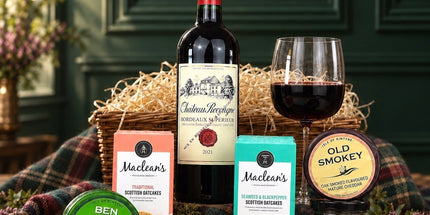 Red wine and Scottish cheese hamper with oatcakes and chutney, styled with cheese wedges and grapes.