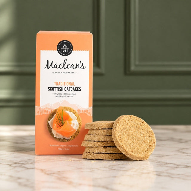 Maclean’s traditional Scottish oatcakes in their orange box, with a stack of round oatcakes on a marble table.