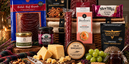 Scottish charcuterie and cheese hamper with oatcakes, chutney, fudge and savoury snacks on a copper table.