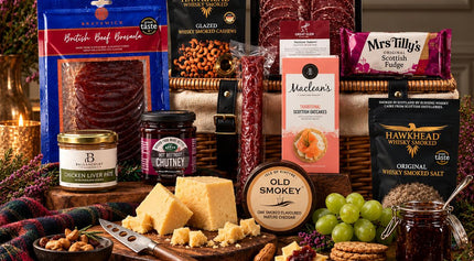 Scottish charcuterie and cheese hamper with oatcakes, chutney, fudge and savoury snacks on a copper table.