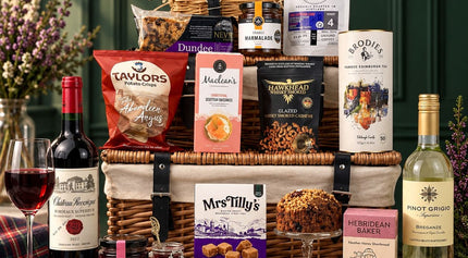 Scottish food and wine hamper with tea, biscuits, cake, fudge, preserves and savoury snacks.