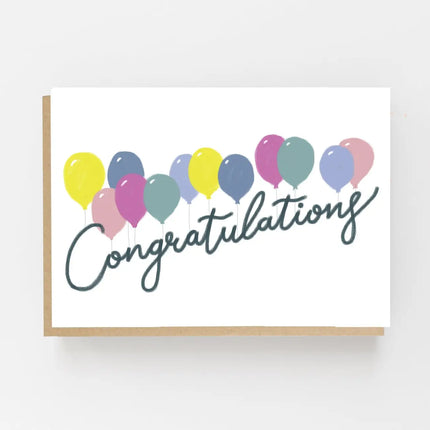 Congratulations greeting card with colourful balloons, dark script lettering and a kraft envelope.