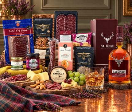 Dalmore 12 whisky and presentation box beside a wicker hamper with venison charcuterie, cheddar, pâté, oatcakes and fudge.