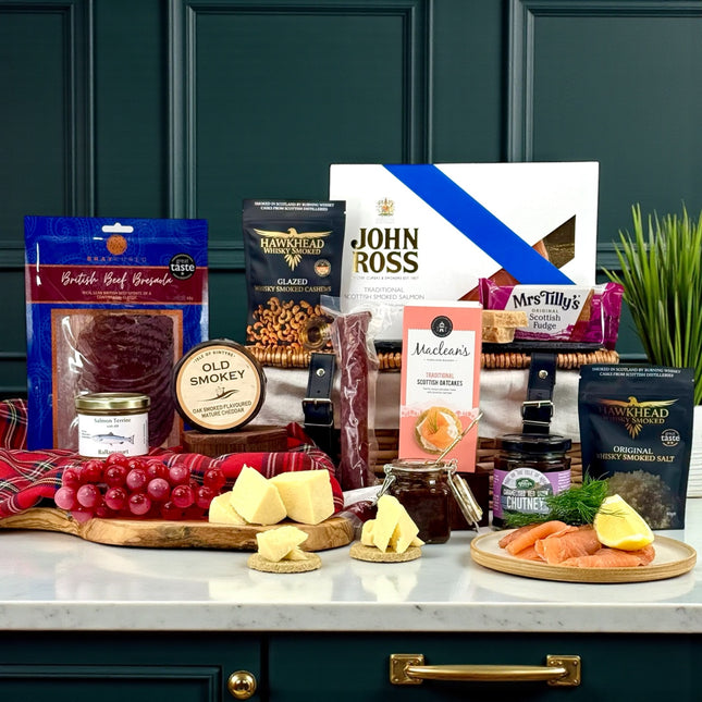 Assorted food products including meats, cheeses, and fruits on a table with a dark green cabinet background.