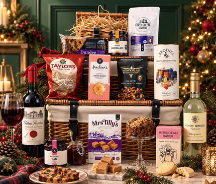 The Glen Coe Christmas Hamper with red and white wine, Scottish treats and wicker baskets in a festive green-panelled setting