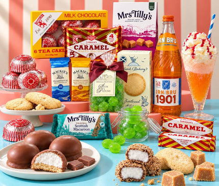 A colorful assortment of British treats and snacks arranged on a bright blue surface against pink-and-white striped paper. Visible products include Mrs.